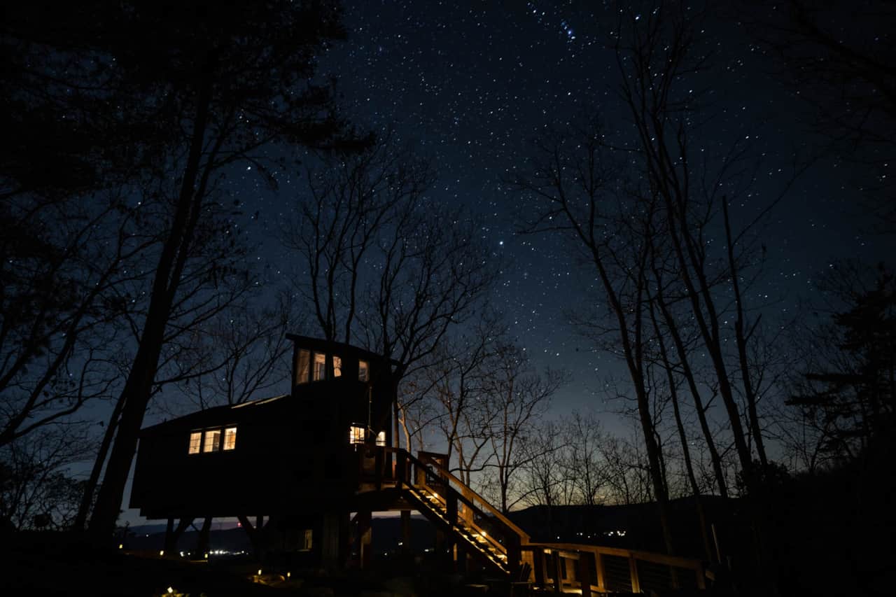 At night, the Sassafras Treehouse becomes a quiet, glowing retreat tucked into the trees.