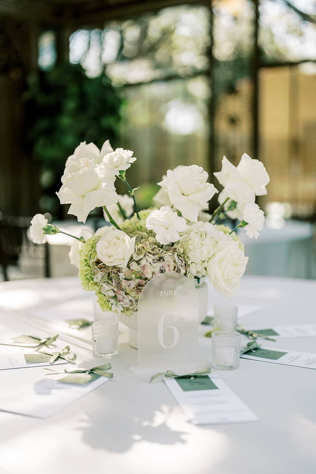White floral wedding tablescape with the Bryan Museum atrium in the background in Galveston, Texas