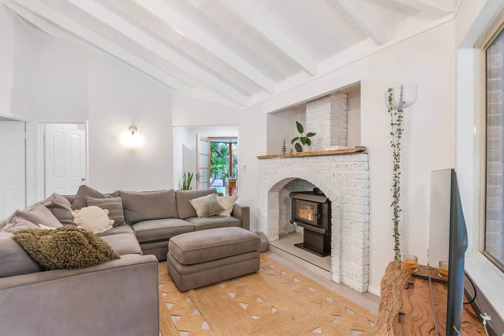 Relax by the cozy fire beneath a grand, rustic mantle — the perfect winter retreat spot.