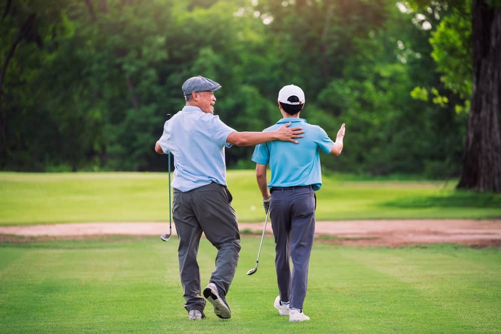 Father and son walking on the golf course