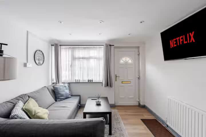 Open-plan living area with sofa bed and 55″ Smart TV — perfect for relaxing or movie nights.