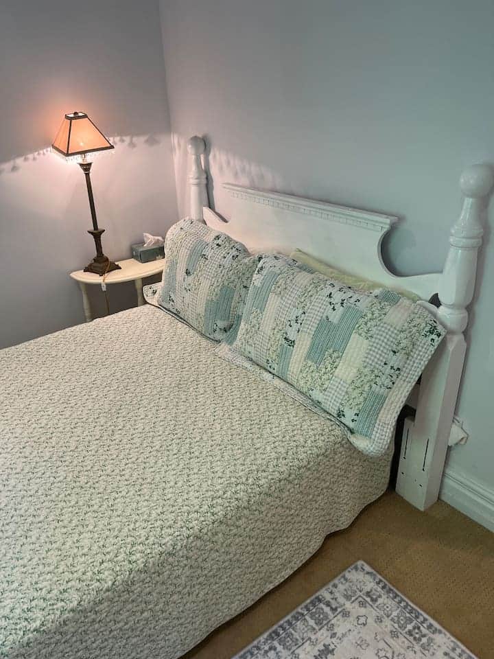 A smaller bedroom with a view of pool,  patio & spruce trees & shared access to a full bathroom. Lockable from the inside. Shared with the twin bedroom occupants. Armoire.