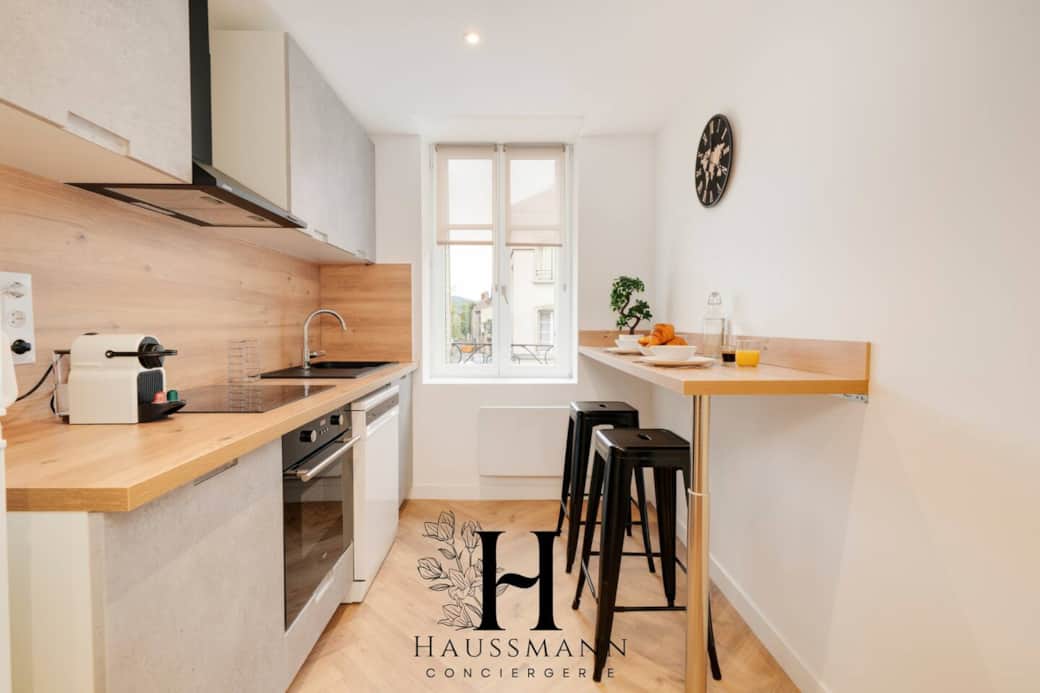 Une cuisine moderne entièrement équipée avec plaque de cuisson, frigo, lave-vaisselle, four, micro-ondes, machine à café, bouilloire et grille-pain, complétée par une table pour deux personnes et des chaises hautes. Une cuisine moderne entièrement équipée avec plaque de cuisson, frigo, lave-vaisselle, four, micro-ondes, machine à café, bouilloire et grille-pain, complétée par une table pour deux personnes et des chaises hautes.