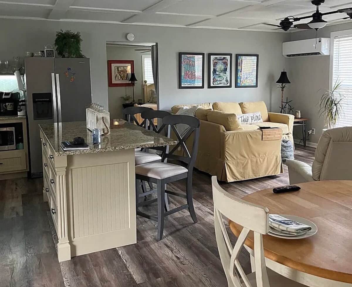 Inviting open living area with comfortable plush seating, bright natural lighting, and a kitchen island with bar seating. Flows seamlessly into the kitchen and dining areas for an easy gathering space.