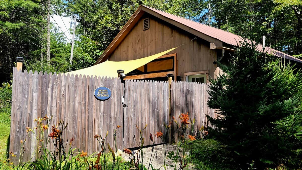 Tucked away among lush greenery, this private guesthouse offers a peaceful retreat. A tall picket fence and dense trees ensure total privacy, while the sun shade creates a cozy, hidden nook perfect for a quiet escape into nature.