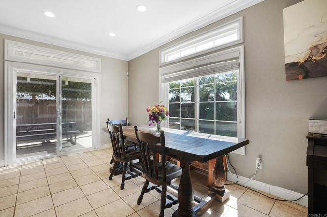 Bright dining space with a wooden table, natural light, and easy patio access.