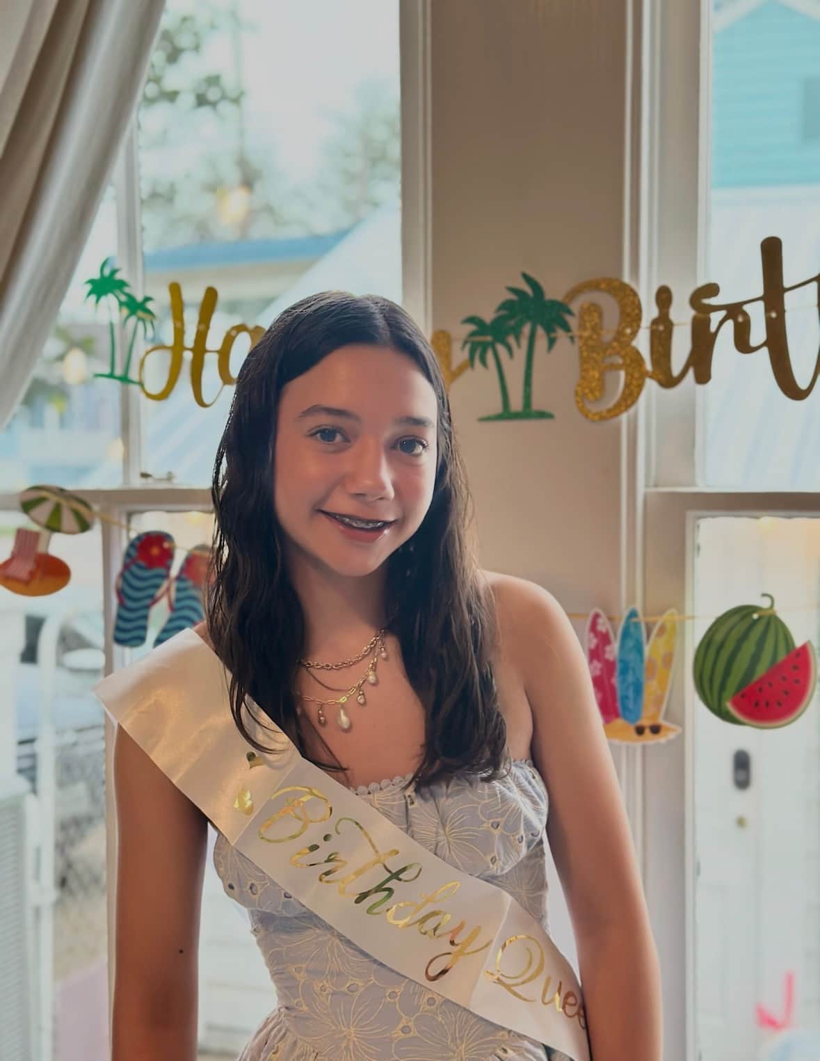 <o, and daughters in front of the photo wall of White Magnolia Galveston during their spring break vacation