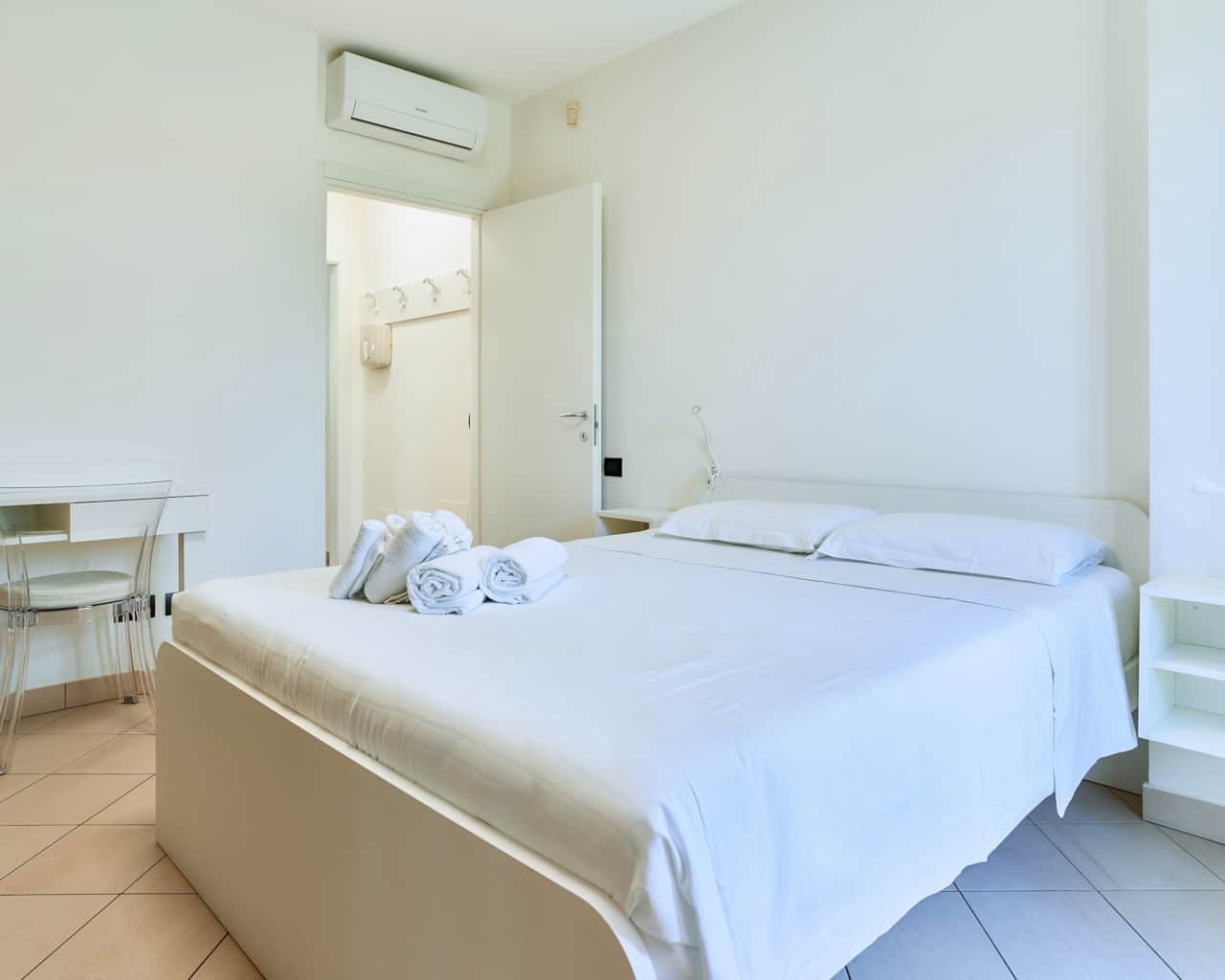 Dormitorio con cama de matrimonio y puerta abierta a la luz