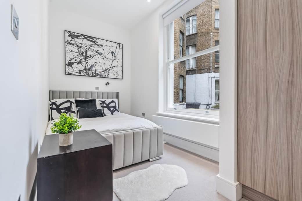 Calm, modern bedroom with a comfortable upholstered bed, fresh linens, stylish artwork and natural light for a restful night’s sleep.