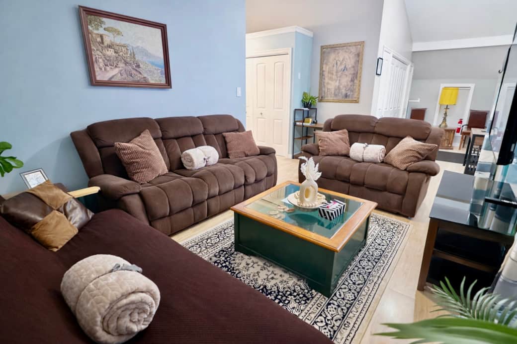 Spacious gathering area with two reclining sofas, one sofa bed, soft throws, and inviting lighting—p Spacious gathering area with two reclining sofas, one sofa bed, soft throws, and inviting lighting—p