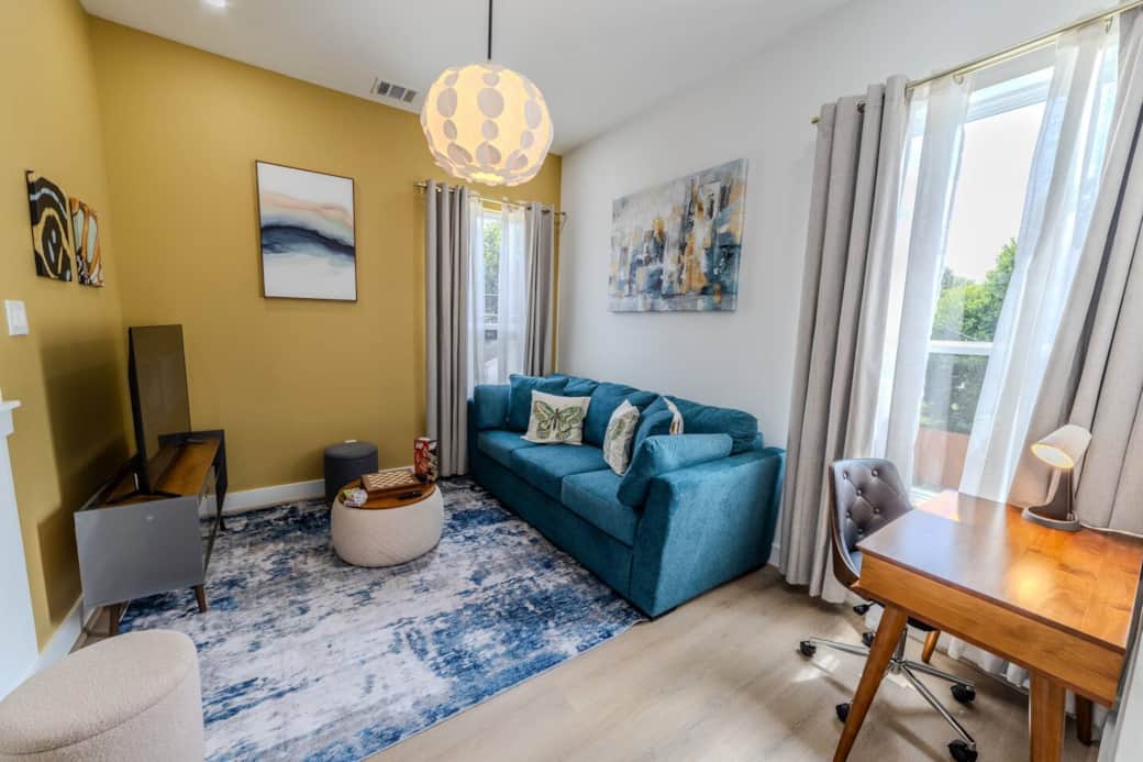 This colorful, multi-purpose game room is perfect for relaxing, playing, or catching up on work. The stylish teal sofa easily converts into a comfortable queen-size bed, offering extra sleeping space for guests or family members. This colorful, multi-purpose game room is perfect for relaxing, playing, or catching up on work. The stylish teal sofa easily converts into a comfortable queen-size bed, offering extra sleeping space for guests or family members.