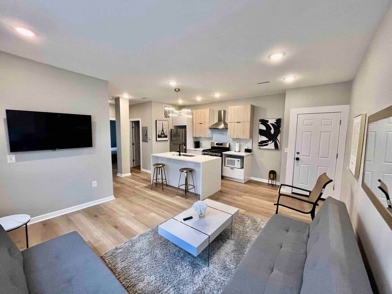 spacious living room! It features 2 futon sofa beds, perfect for accommodating extra guests. Enjoy your favorite shows on the 50-inch TV,  Cozy up by the fireplace underneath for a warm atmosphere. There’s a door that leads to a small balcony outside