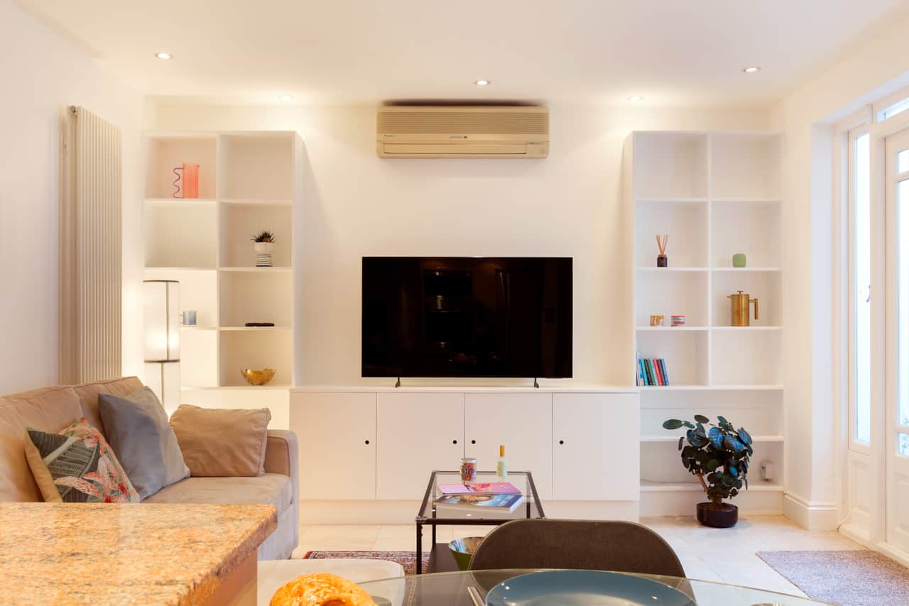 Living room shelving detail with books, brass jug and decorative objects