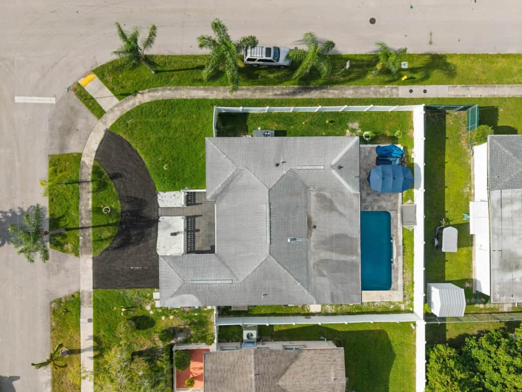 Overhead view capturing the home’s spacious layout and enclosed yard, creating a private retreat perfect for relaxation and family stays.