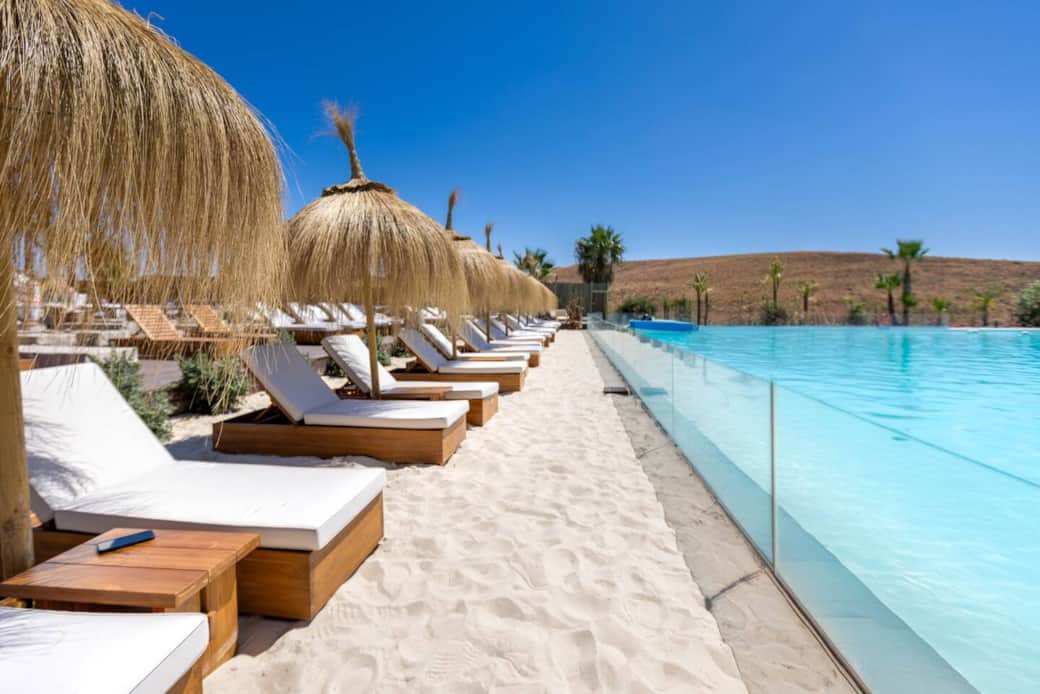 Private white-sand lagoon beach with sunbeds and palms. Private white-sand lagoon beach with sunbeds and palms.