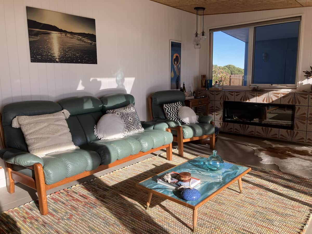 A lounge room that is warm, mid-century, lived in and calm.