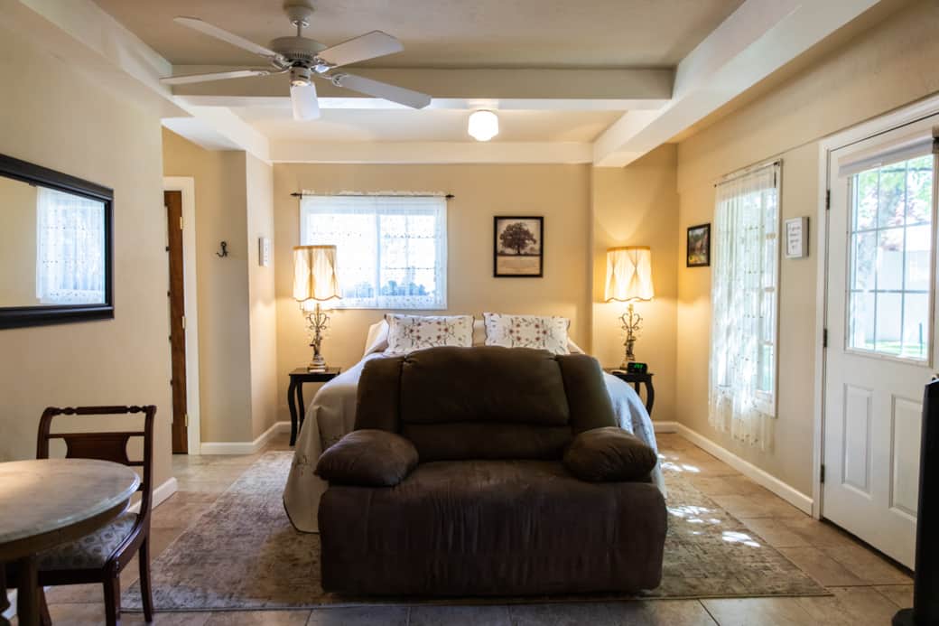 Cozy guest room with soft light, plush bedding, and inviting vintage charm