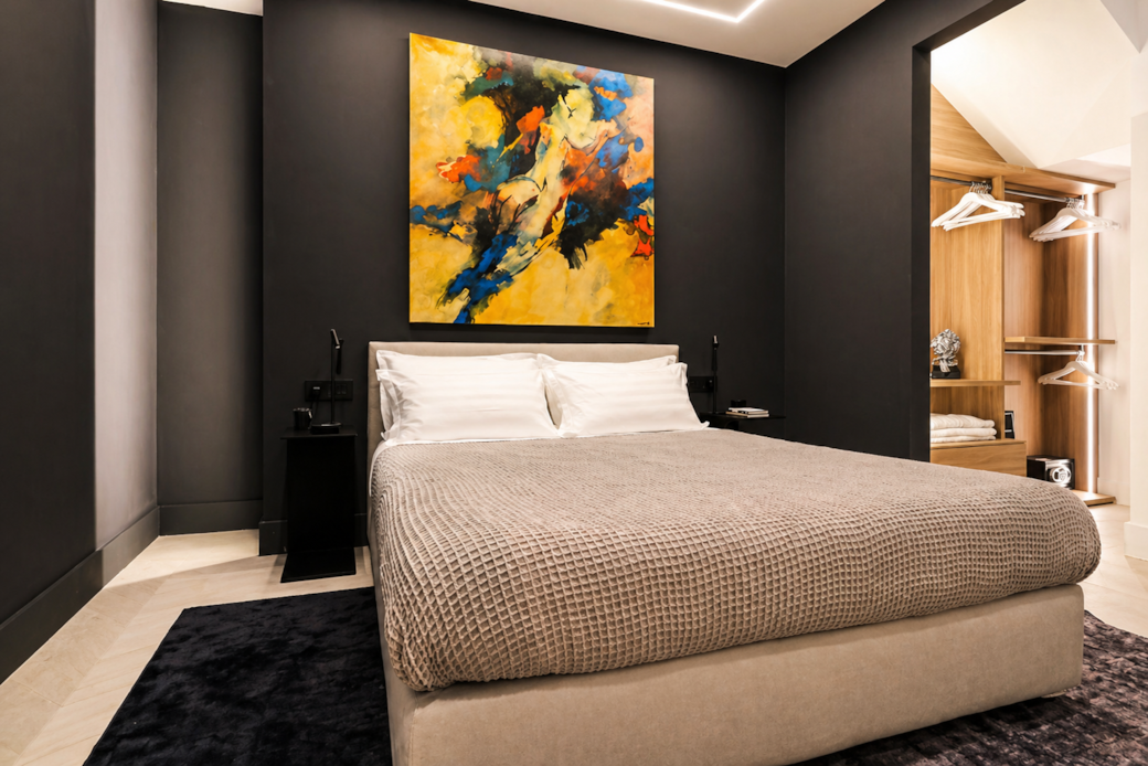 Rental12 olbia modern bedroom double bed dark accent wall abstract art open wardrobe