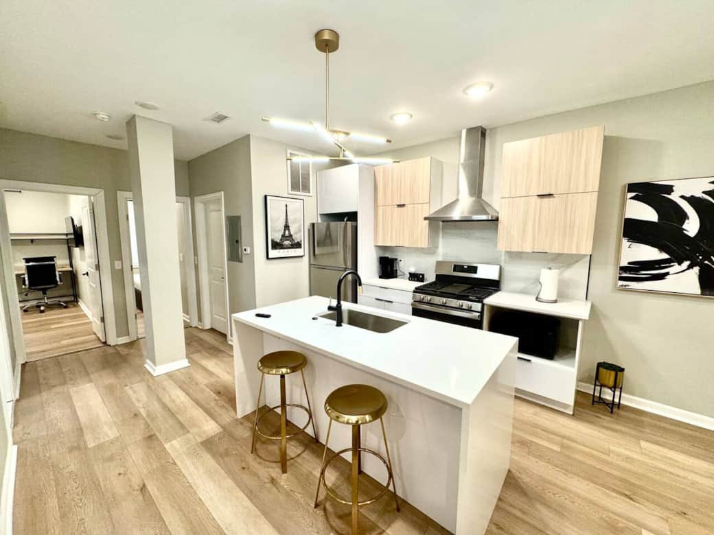A fully equipped kitchen, including a beautiful waterfall quartz breakfast bar. You'll have access to a range with a hood, a microwave, a dishwasher, a refrigerator, and a garbage disposal, making it convenient for all your cooking and dining needs