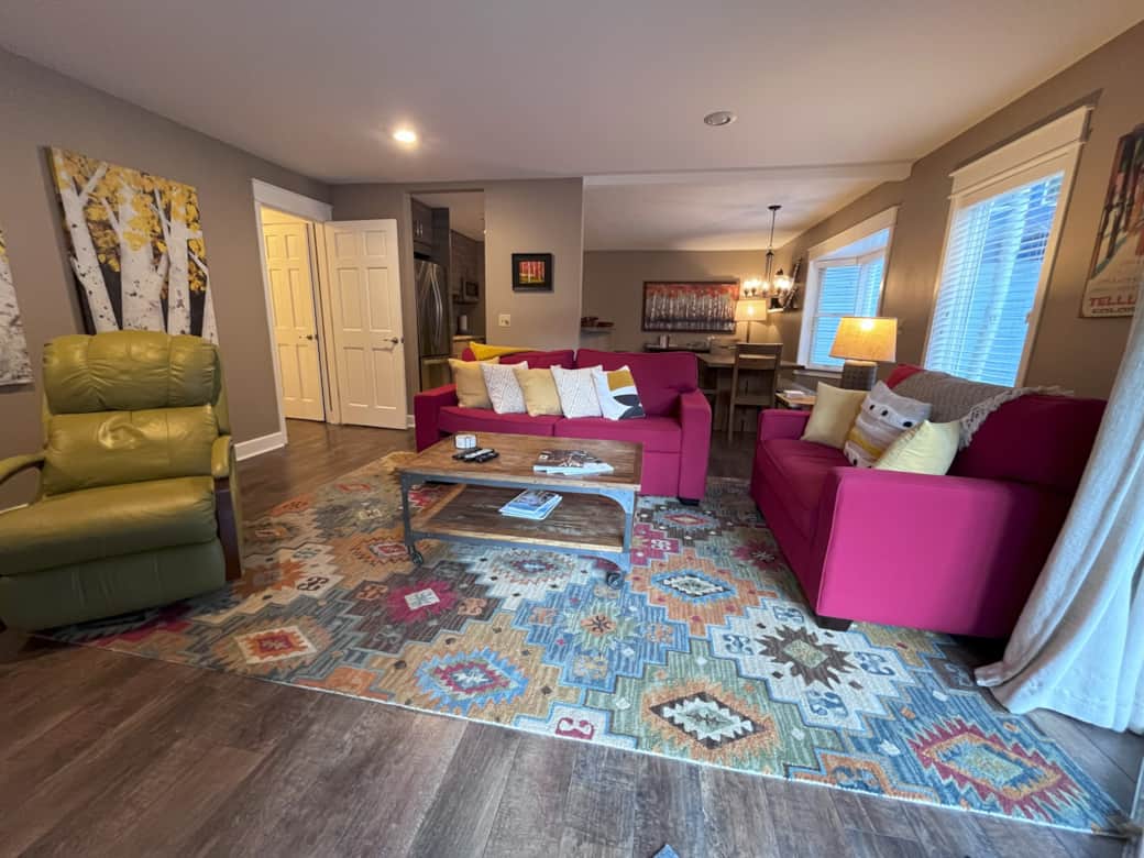 The living room features a queen-sized sleeper sofa for extra bedding