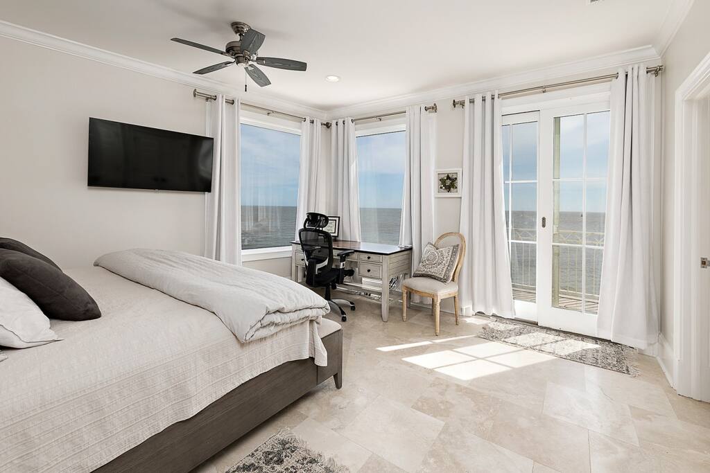 View from master bedroom with flat screen tv, workspace and private deck.