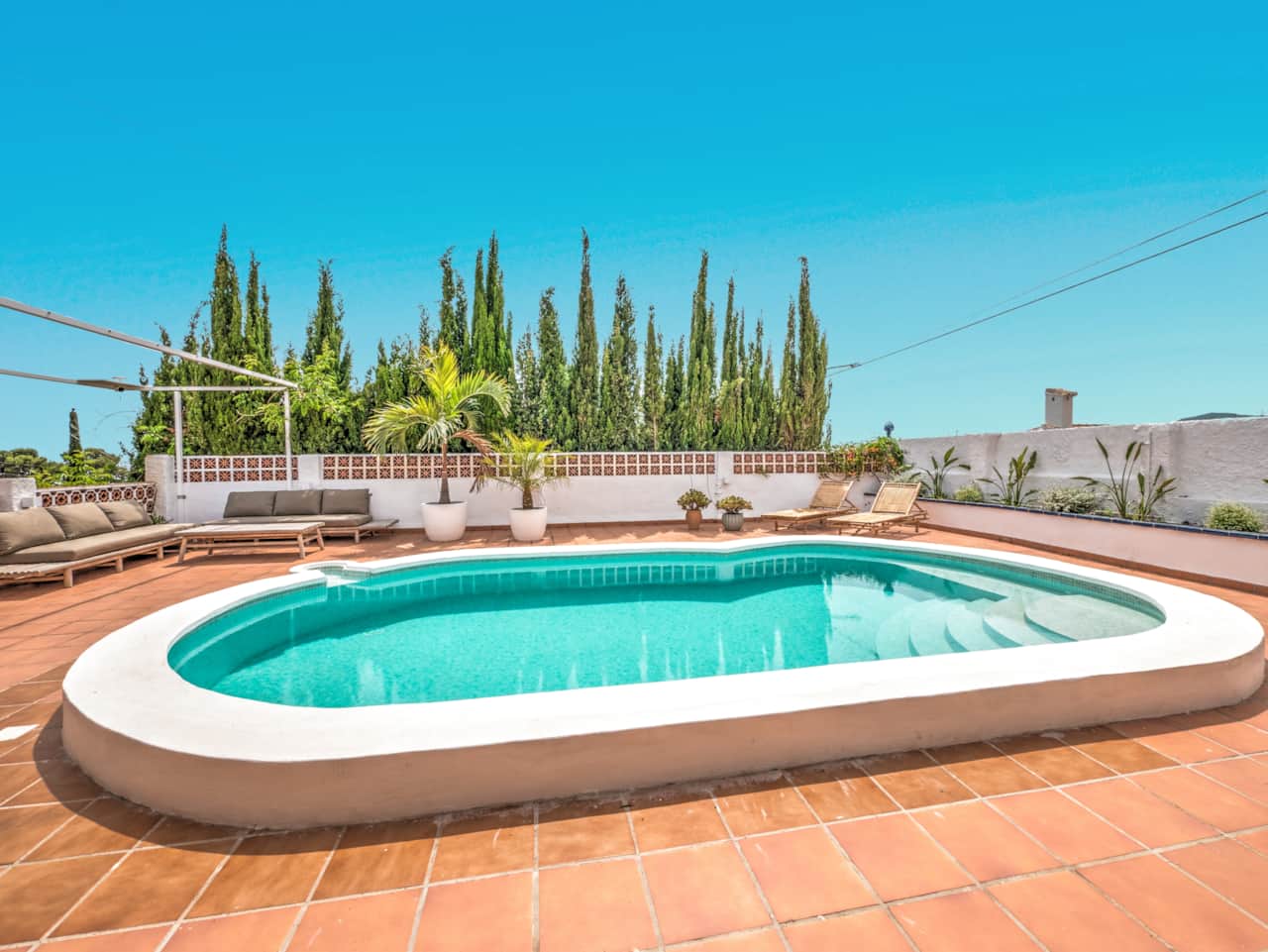 La piscina privada, zona de estar y tumbonas.