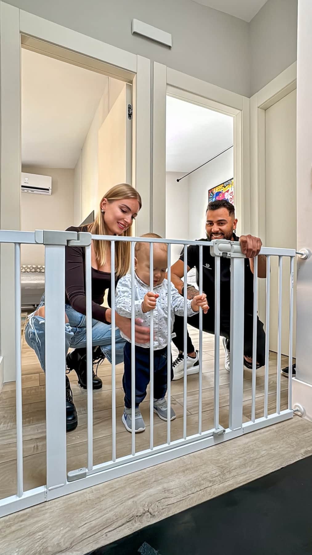 Parents watching baby at safety gate near the stairs, supplied by RENTAL12 family welcome kit in Olbia