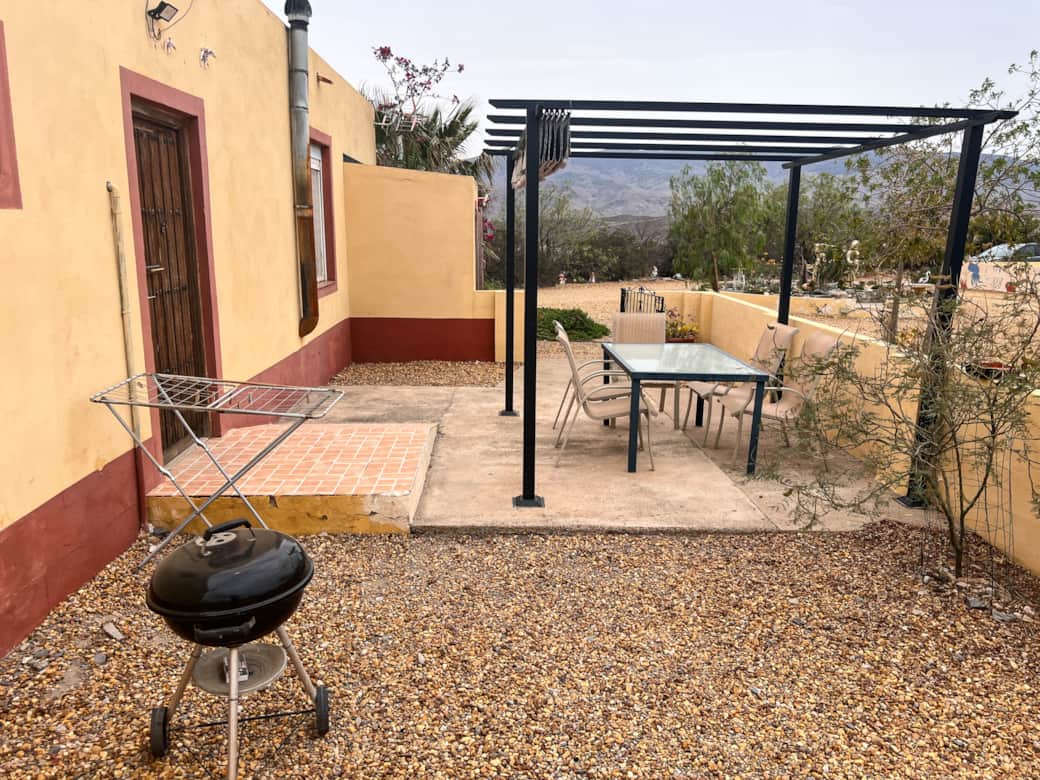 Patio privado con parrilla, mesa de comedor y sombrilla ajustable