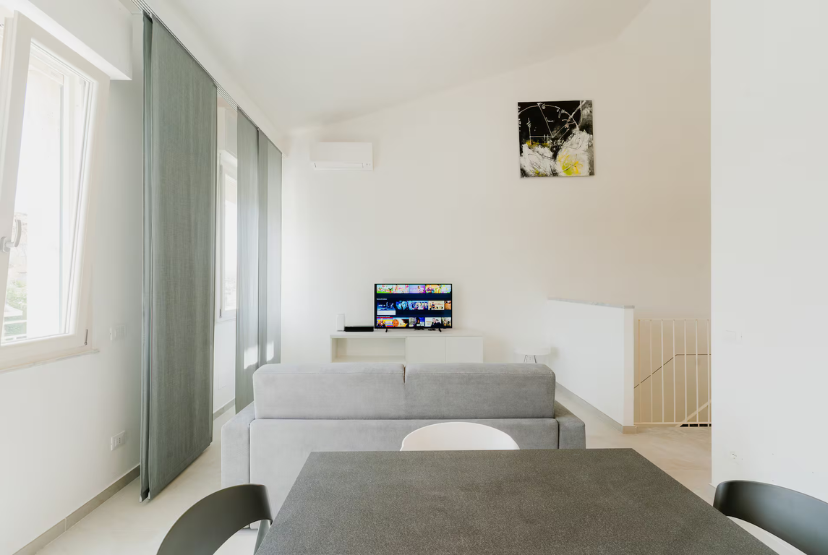 Zona giorno di CasaGiallo Versilia: soggiorno open space con divano letto, design moderno fronte mare Marina di Pietrasanta