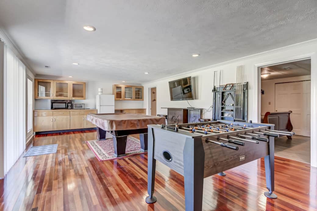 Downstairs entertaining space with billiards, foosball, a gaming console and seating area. Downstairs entertaining space with billiards, foosball, a gaming console and seating area.