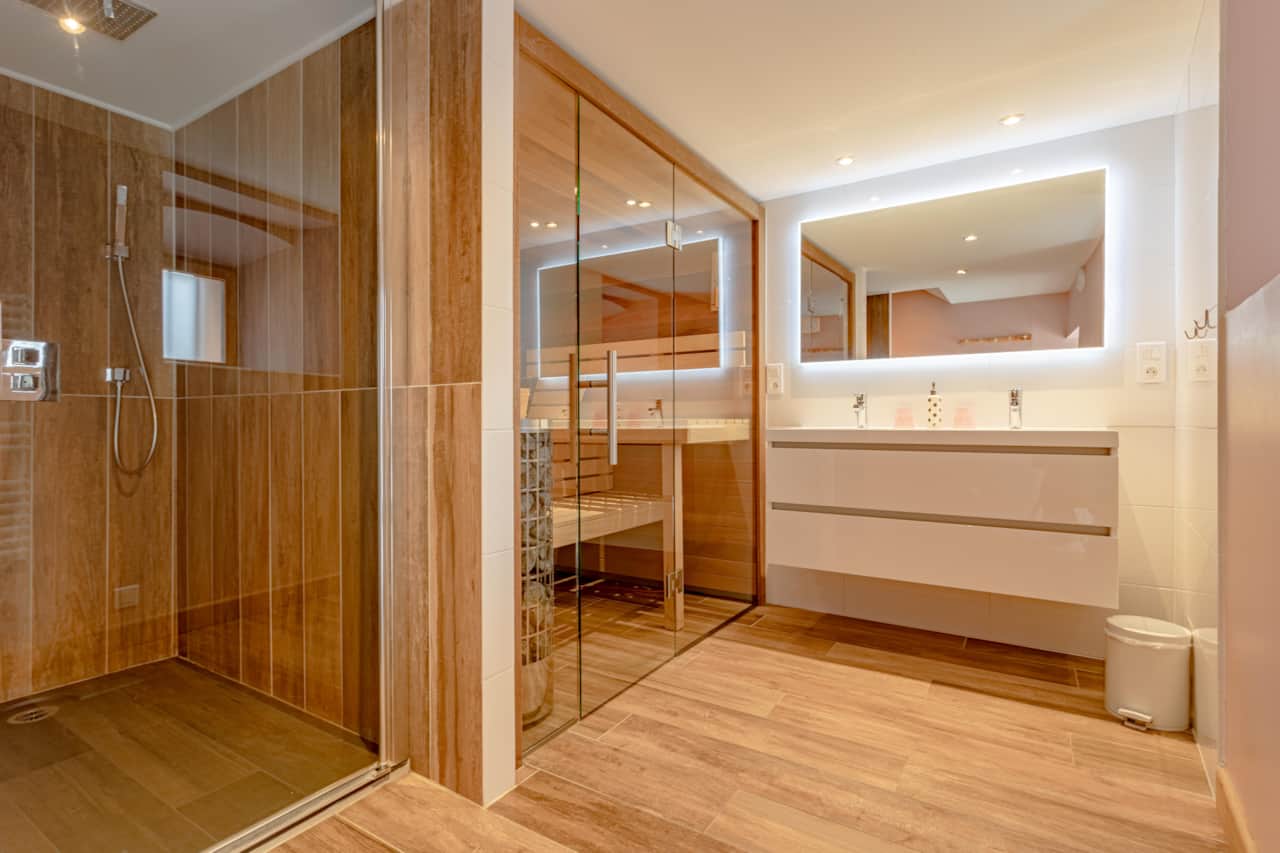 Relaxation area with private sauna, modern shower and double sink, for optimal comfort.