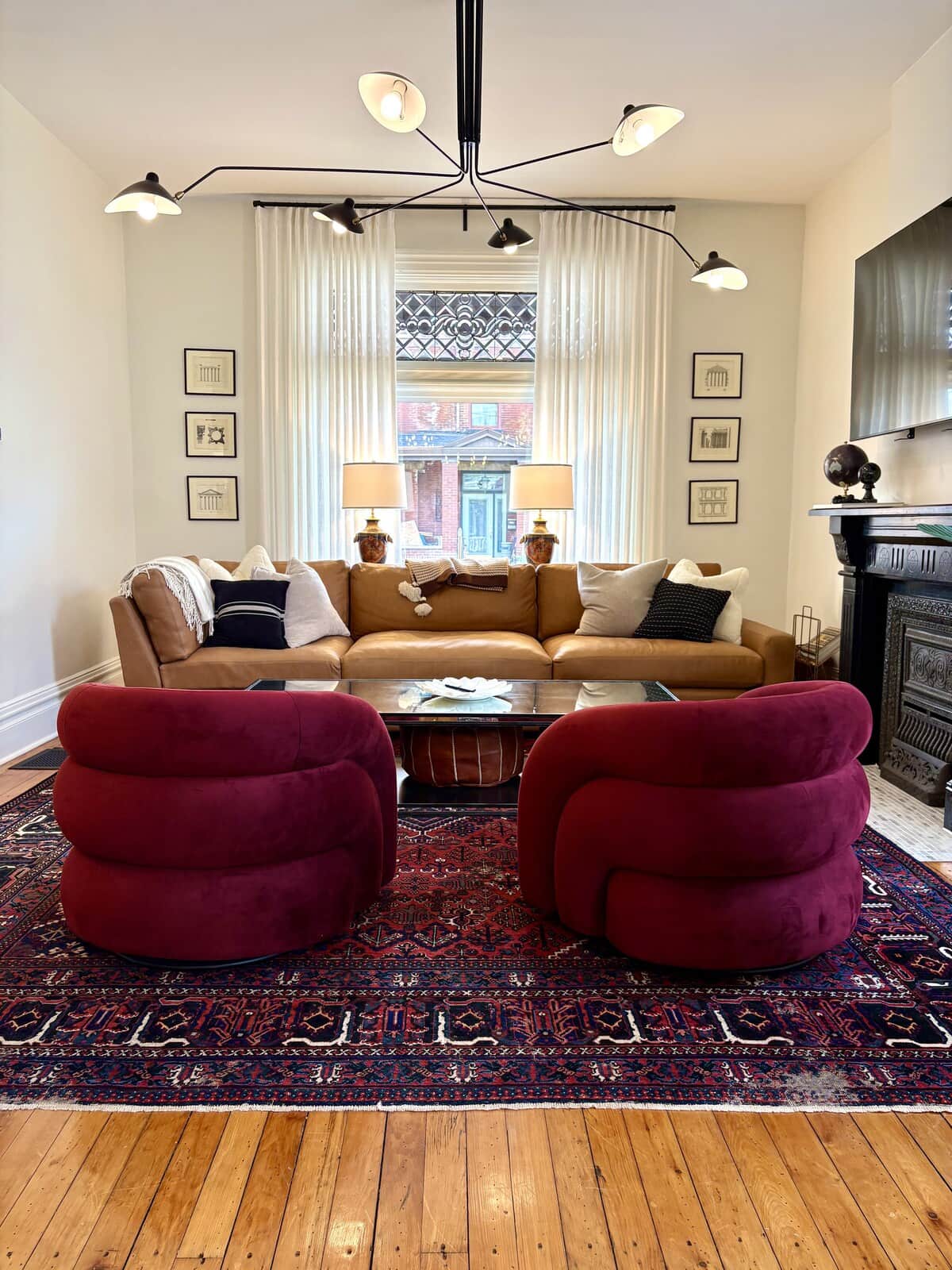 Burgundy velvet swivel chairs, a vintage Persian rug, and a black cast-iron fireplace in Sharpsburg