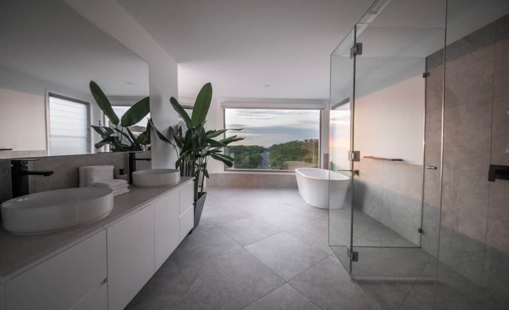 Modern ensuite with double vanity, rain shower, and luxury finishes.