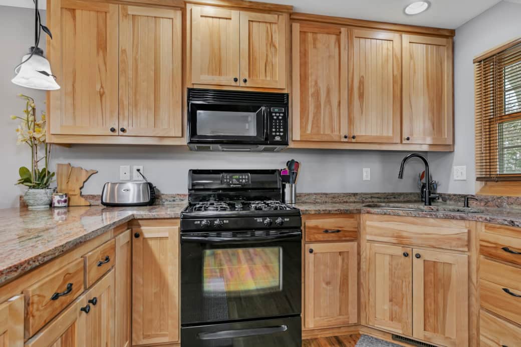 Kitchen area with sink, stove, microwave, and toaster Kitchen area with sink, stove, microwave, and toaster