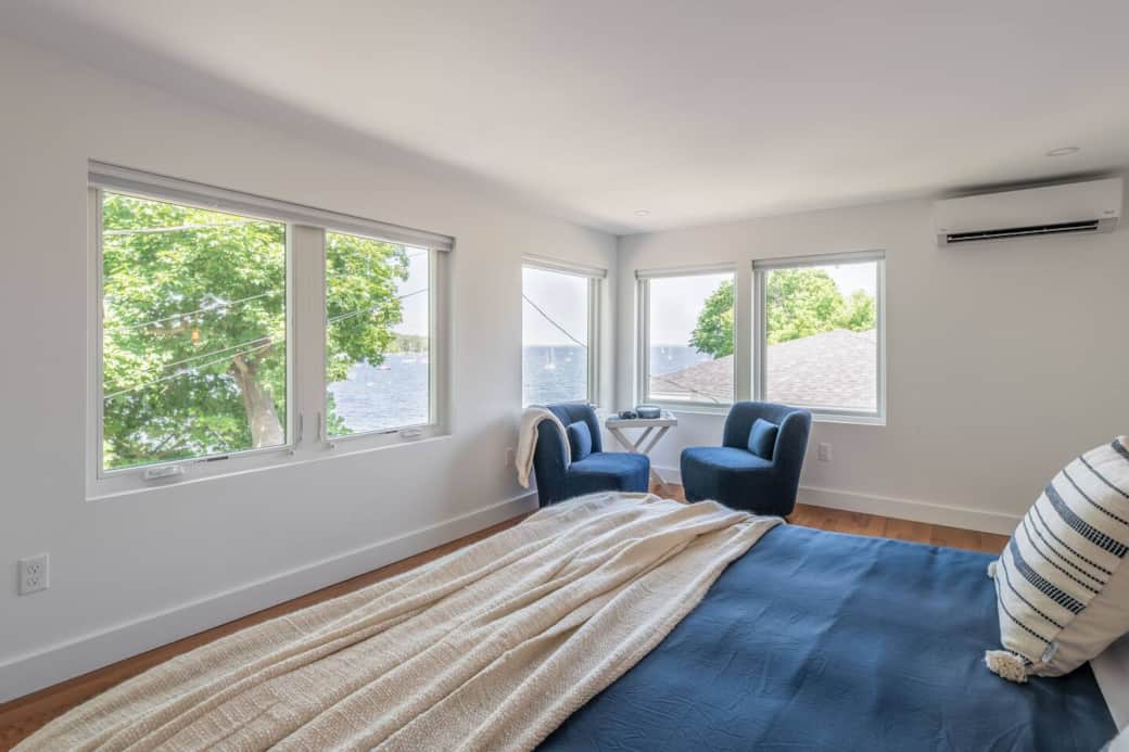 Second floor bedroom with king-sized bed and arguably the best view in the house!

 Also notice the heat pump for your comfort. Just out of view to the right is a small walk-in closet with a dresser, luggage rack & a rod to hang clothes.