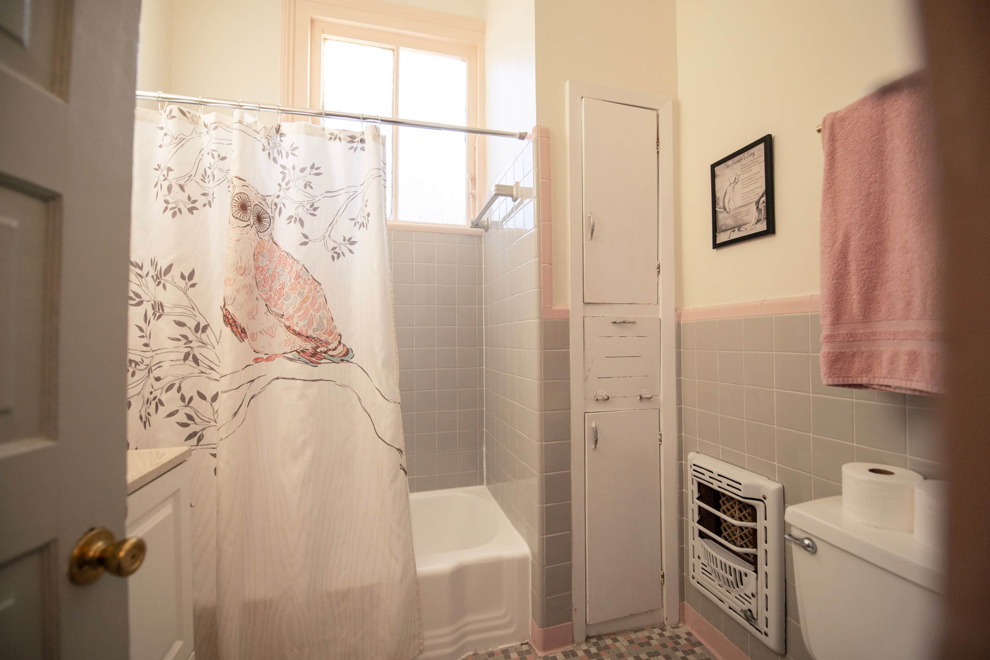 A bathroom with a shower, bathtub, toilet, and window.