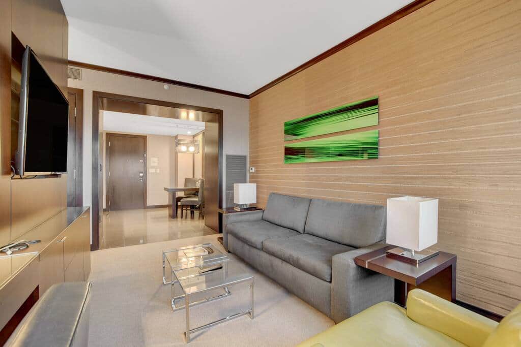 Spacious Living Area with Sofa, TV and Wall-to-Wall Glass