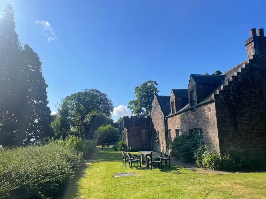 Row of four Victorian cottages and grass covered garden. The garden runs along the back of the row o Row of four Victorian cottages and grass covered garden. The garden runs along the back of the row o