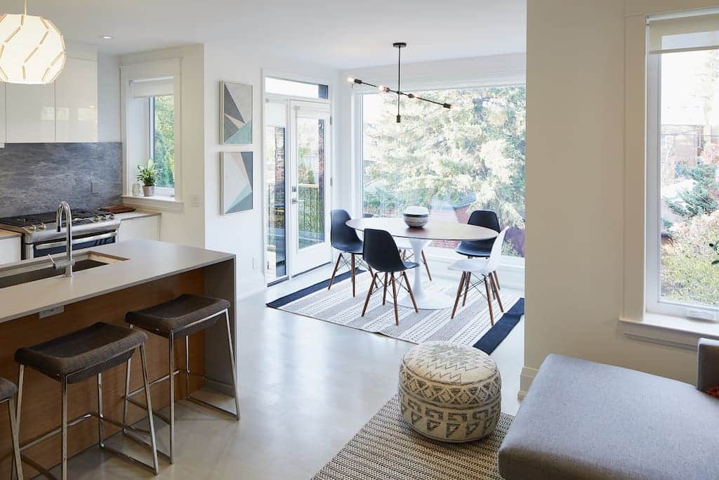 Floor-to-ceiling windows allow natural light to fill the dining room, living room and kitchen.
