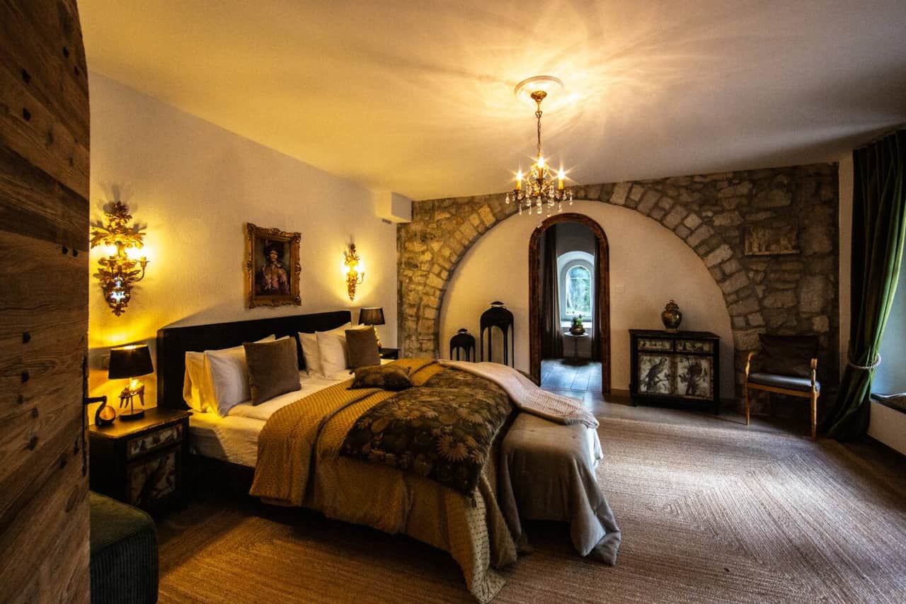 King bedroom with original stone arch and courtyard-facing windows