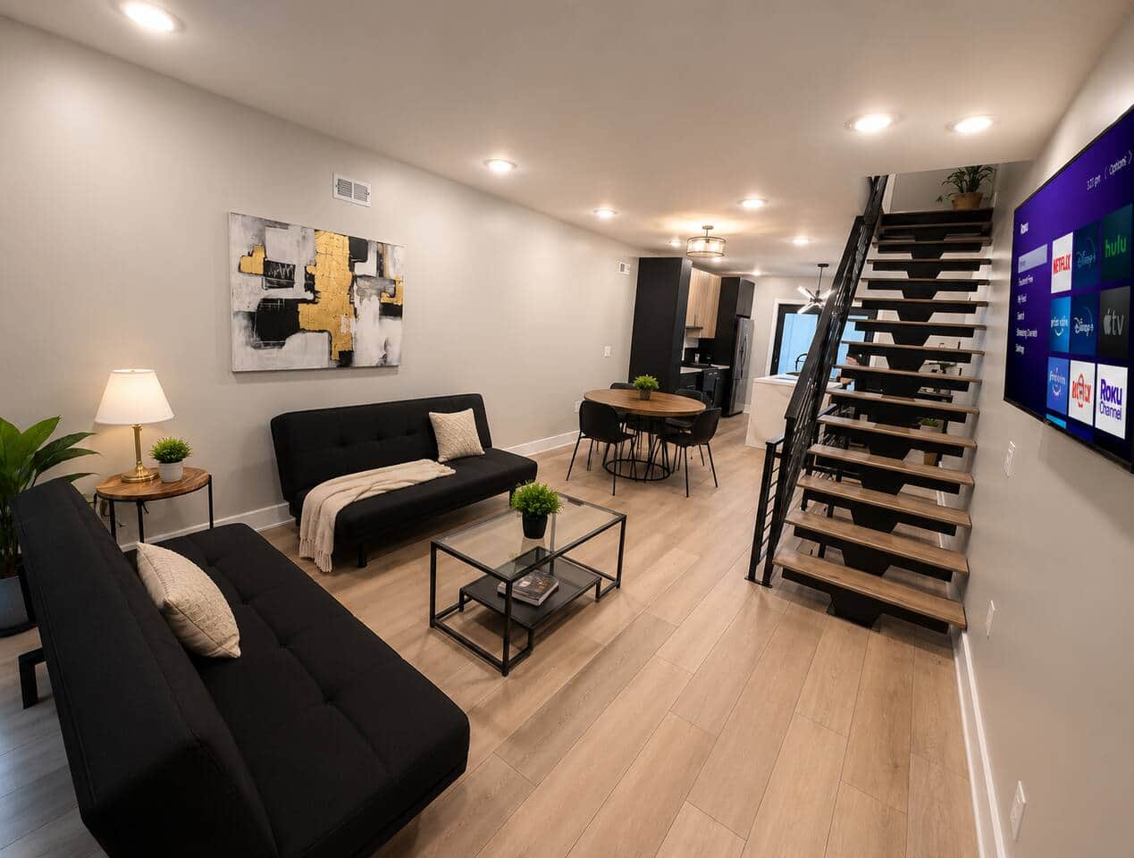 Relax in this spacious living area featuring two comfortable futon sofa beds, a large flat-screen Roku TV, and modern décor. It’s the perfect place to unwind, stream your favorite shows, or provide additional sleeping space for extra guests.
