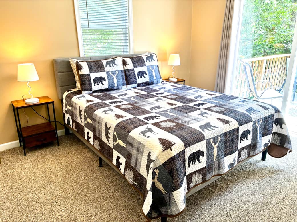 Queen bedroom with deck access for peaceful mornings surrounded by nature.