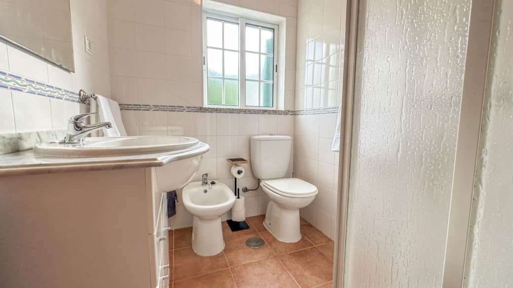 The bathroom has a shower, bidet, and vanity.