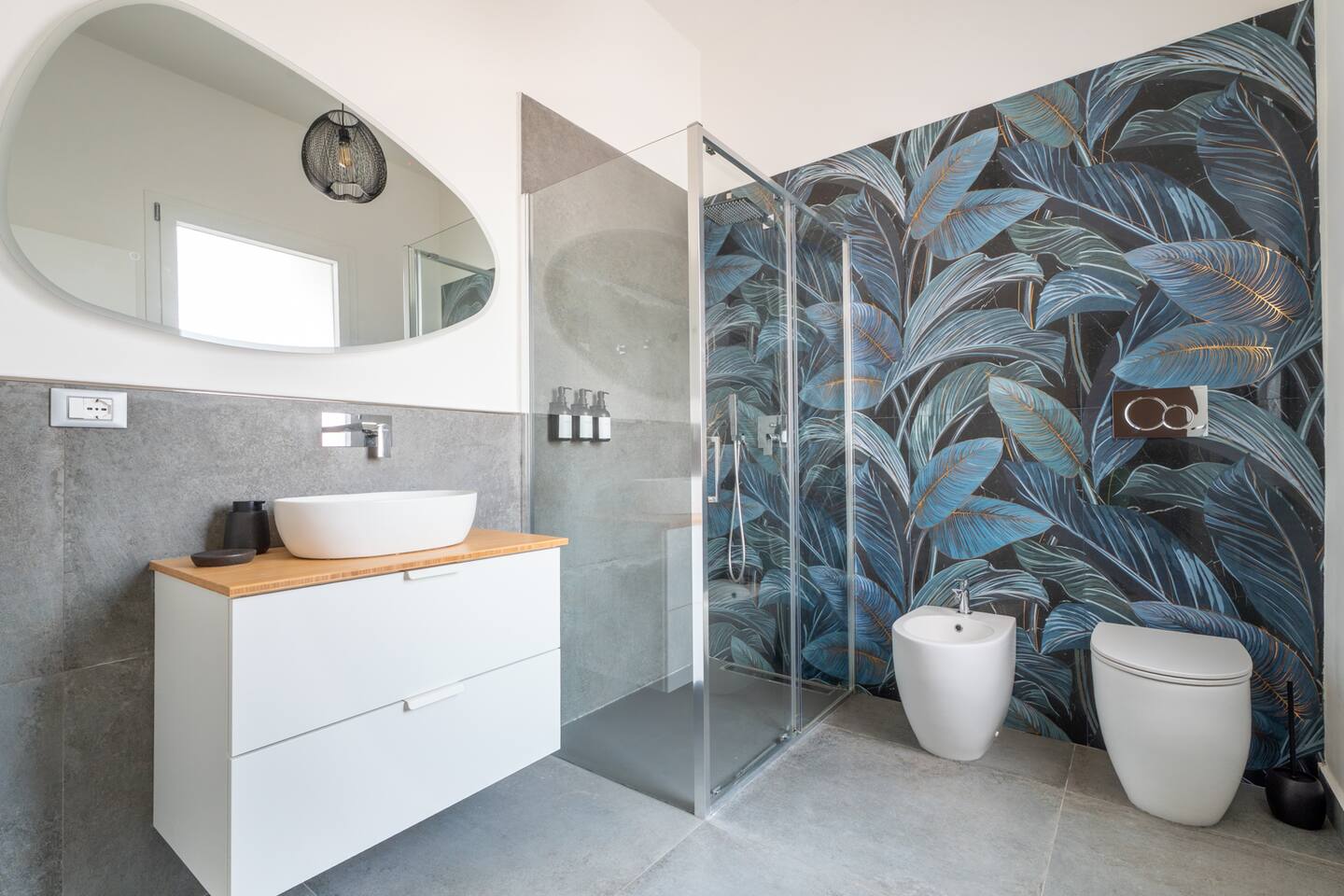 Bagno in stile tropicale, luminoso e rigenerante. Doccia filo pavimento spaziosa con un grande soffione a pioggia per un effetto cascata. Ampia finestra. Specchio anti appannamento. Linea cortesia premium, morbidi asciugamani, asciugacapelli. 