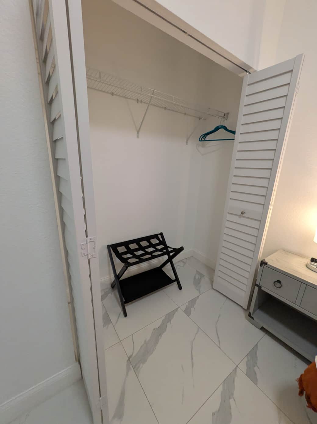 Bedroom 3: Closet, luggage rack & warm lighting.