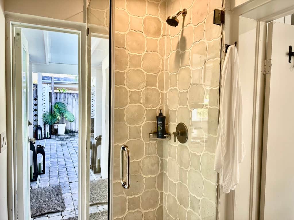 Renovated Unit 3 bathroom at Casa Citron using glass shower enclosures to visually open the space, improving light and perceived openness despite the compact layout.