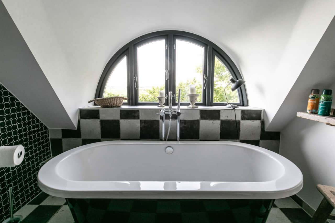 Bathtub beneath the arched window