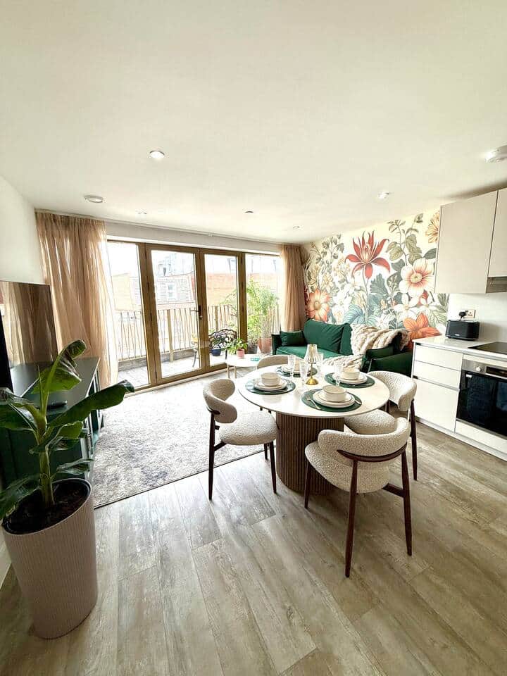The living room of this modern flat features a 55” TV, stylish wood details and a comfy sofa bed. Enjoy direct access to a spacious private terrace with outdoor furniture and plants – ideal for families or friends to relax after exploring London The living room of this modern flat features a 55” TV, stylish wood details and a comfy sofa bed. Enjoy direct access to a spacious private terrace with outdoor furniture and plants – ideal for families or friends to relax after exploring London