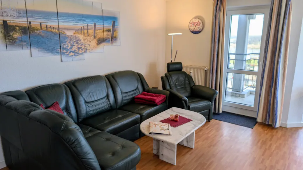 Living room with leather sofa and access to the balcony
