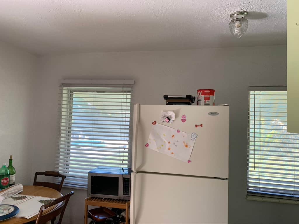 Before renovation: Unit 2 dining area at Casa Citron with refrigerator located in the dining space, limiting layout efficiency and guest comfort.